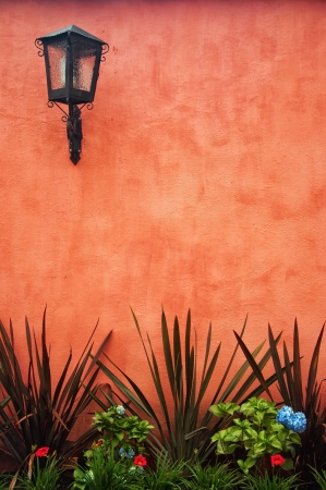 A red colonial wall with a lantern in the upper left の写真素材