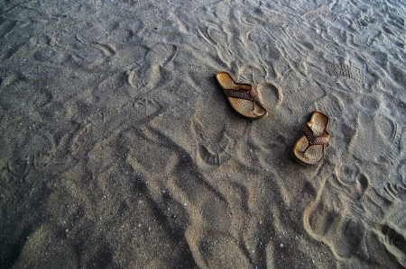 Flip flops in the sand at a beach の写真素材