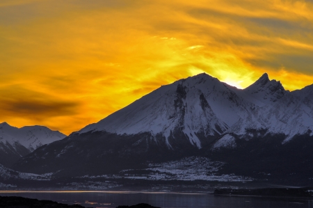 An orange sky at sunset behind a mountain in Tierra del Fuego の写真素材
