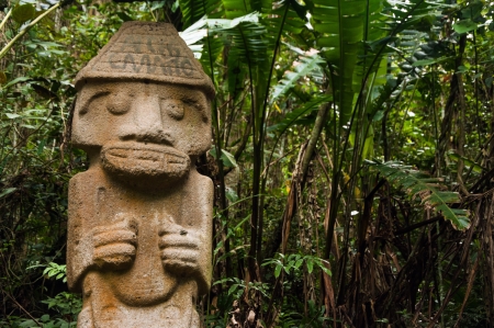 An ancient statue that has been vandalized and painted with graffiti 