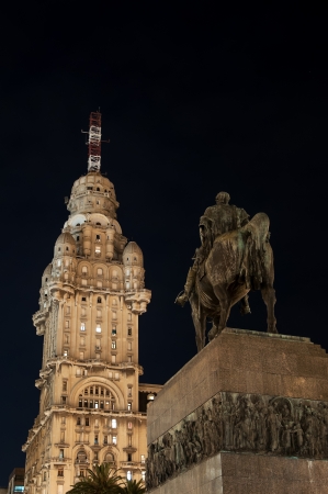 Public statue of General Artigas and towering skyscraper in Montevideo at nightのeditorial素材