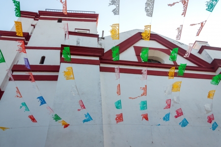 View of white church with waving flagsの写真素材