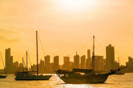 Boats and skyscrapers at sunset in Cartagena, Colombiaの写真素材