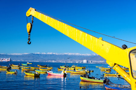 Colorful fishing boats and yellow crane in Coquimbo, Chileの写真素材