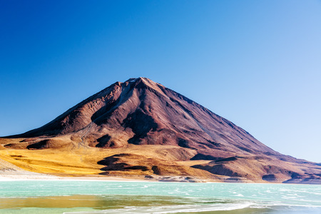 View of Licancabur Volcano and the emerald green Laguna Verda on the border of Chile and Boliviaの写真素材