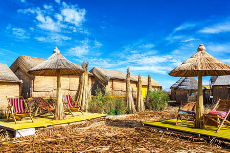 Houses and umbrellas made out of reeds on Uros floating islands on Lake Titicaca near Puno, Peruのeditorial素材