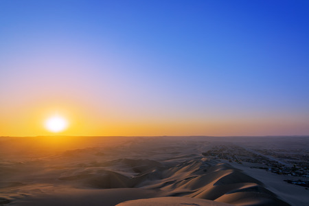 View of the sun setting over sand dunes in Huacachina, Peruの写真素材
