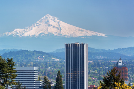 Skyscrapers in downtown Portland Oregon with Mount Hood rising above themの写真素材