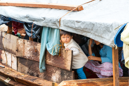 TAMSHIYACU, PERU - MARCH 11: Young child on a wooden boat in Tamshiyacu, Peru in the Amazon Rain Forest on March 11, 2015のeditorial素材