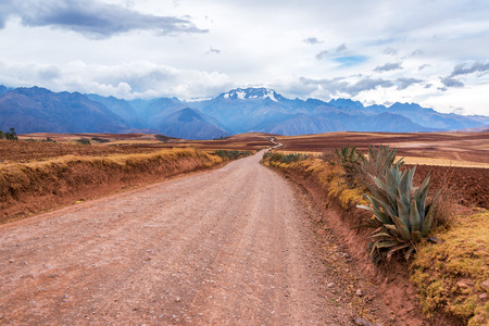 Dirt road leading to the Andes mountain range in the Sacred Valley of Peruの写真素材