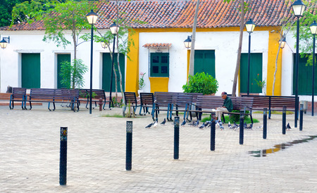 MOMPOX, COLOMBIA - MAY 28: Elderly man feeds pigeons in a plaza in Mompox, Colombia on May 28, 2016のeditorial素材