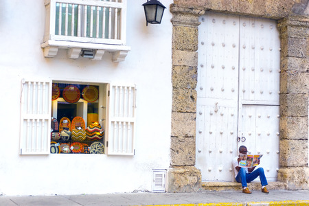 CARTAGENA, COLOMBIA - MAY 25: Shop selling souvenirs and a man sitting on the sidewalk in Cartagena, Colombia on May 25, 2016のeditorial素材