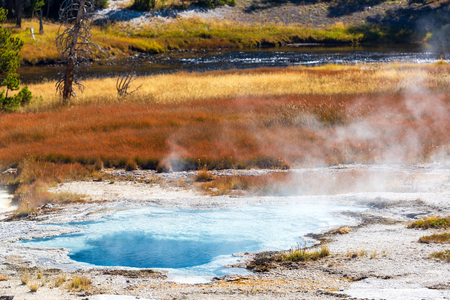 Pool with steam coming off of it in the Upper Geyser Basin in Yellowstone National Parkの写真素材