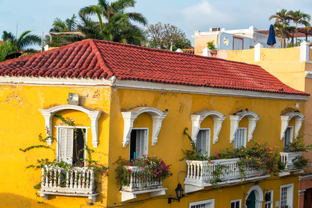 Historic yellow colonial building with bougainvillea flowers on the balconies in Cartagena, Colombiaの写真素材