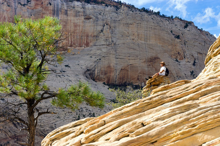 ZION NATIONAL PARK, UT - SEPTEMBER 14: Man sits on a rock on Angels Landing in Zion National Park in Utah on September 14, 2015のeditorial素材