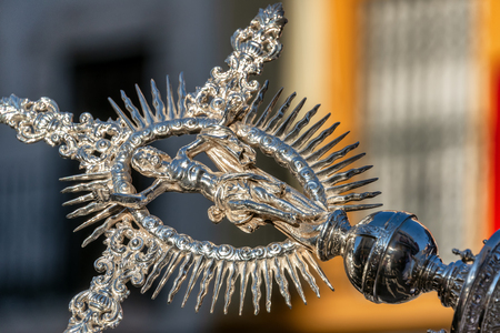 Ornate Jesus ornament at the end of a long pole carried by a priest in Seville, Spain during Holy Weekの写真素材