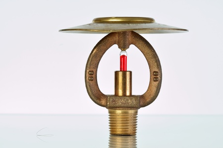 Close up image of fire sprinkler on white. Fire sprinklers are part of an integrated water piping system designed for life and fire safety.の写真素材