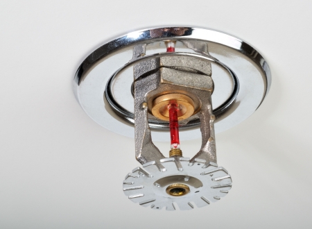 Close up image of fire sprinkler on white. Fire sprinklers are part of an integrated water piping system designed for life and fire safety.の写真素材