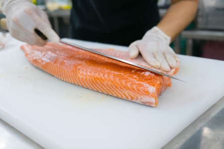 chef cutting salmonの写真素材