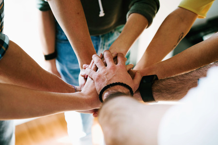 Group of people joining hands together. College students teamwork stacking hands.Young entrepreneurs brainstorming on the new ideas. Teamwork unity and solidarity. Business cooperation.の写真素材