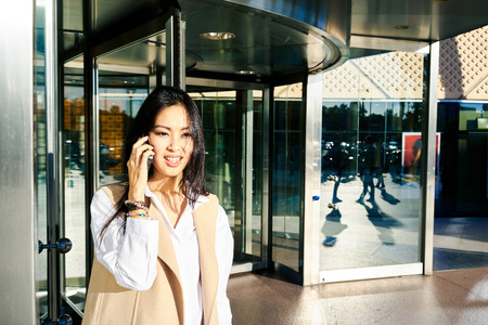 Young attractive asian business woman making a business call outside the business center.の写真素材