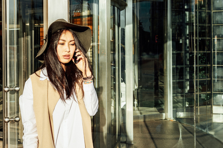 Young attractive asian business woman making a business call outside the officeの写真素材