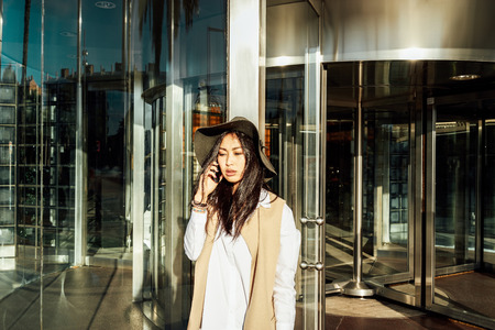 Young attractive asian business woman making a business call outside the officeの写真素材