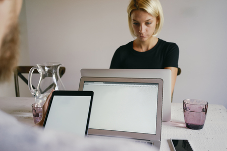 Man typing on laptop against young women and using digital tablet with blank empty screen for your information or content . brainstorming togetherの写真素材