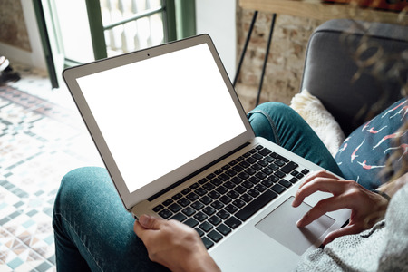 Female person sitting front open laptop computer with blank empty screenの写真素材