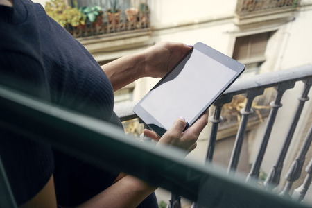 Close up to view young woman's hands hold tablet on the balconyの写真素材