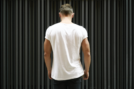 blank white t-shirt on muscle young man, black wall backgroundの写真素材
