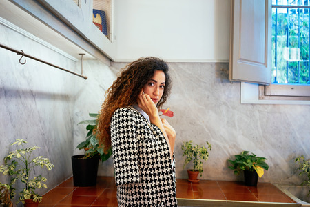 Young attractive businesswoman with long curly hair talking on cell telephone.brunette Caucasian girl talking on smart-phone in coffee-shopの写真素材