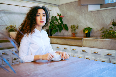 young attractive girl drinking coffee in a coffe-shop.Beautiful business woman drinking coffee before a meeting with a business-partnerの写真素材