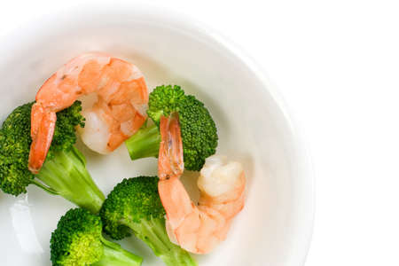 Cooked shrimps and green broccoli florets in a white bowlの写真素材