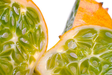 A juicy sliced open horned or Kiwano melon showing the seeds and yellow-green fleshの写真素材