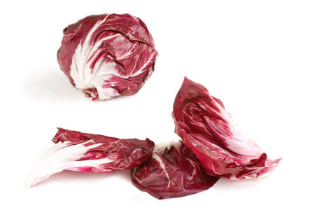 Fresh deep red white veined radicchio leaves with head in backgroundの写真素材