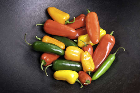 Colorful sweet and jalapeno peppers in a black cast iron potの写真素材