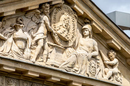 Paris, France - May 1, 2020: Private house with statue on the pediment in Paris