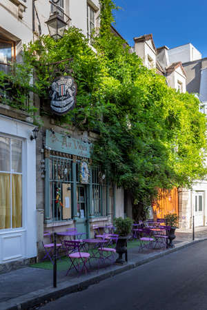 Paris, France - September 9, 2020: One of the oldest street cafe in Paris Au vieux Paris d'Arcole with violet chairs and glycine after the first lockdownのeditorial素材