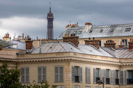 Paris, France - June 30, 2020: Beautiful buildings, typical facades, with the Eiffel Tower in backgroundのeditorial素材