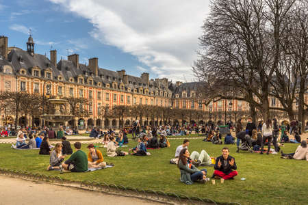Paris, France - February 21, 2021: People relaxing on green lawns of famous Place des Vosges - oldest planned square in Paris, during covid-19 pandemic.のeditorial素材