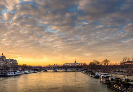 Paris, France - February 12, 2021: Seine river and Grand Palais in background with a beautiful cloudy sunset in Parisのeditorial素材