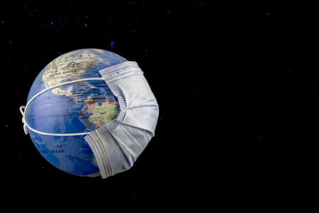 Earth globe with surgical mask floating on black background