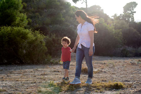 Woman with her son walking and enjoying the countryside far from the city