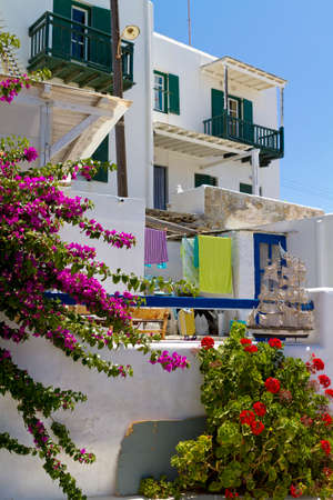 Typical whitewashed houses and blue painted doors and windows with colorful plants on the island of Mykonos in Greeceのeditorial素材