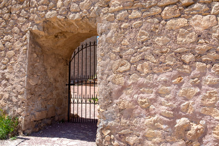 grill door in wide stone wall of the medieval period as protection of the castle.のeditorial素材