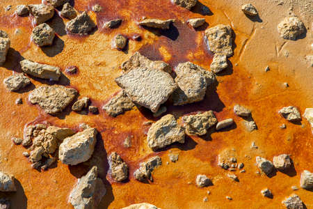 set of different stones on a reddish mud floor illuminated by the sun, concept textures or...