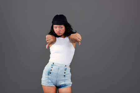pretty young asian girl with bandana, thumbs down and disapproving gesture