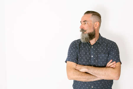 40-45 year old bearded hipster style man, serious with arms folded looking to the sideの写真素材
