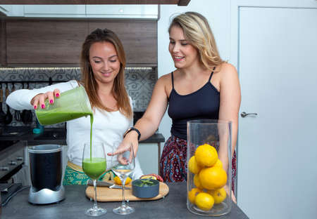 Vegan lesbian couple, preparing spinach smoothie. LGBT concept, vegan peopleの写真素材